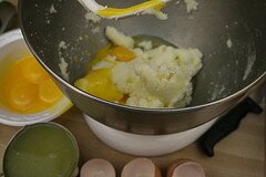 Adding in eggs and yolks, beat together