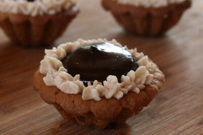 A peanut butter cookie tartelette filled with dark chocolate almond ganache and edged with Peanut butter infused whipped cream.